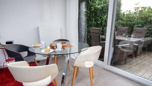 A modern dining area with a glass table, white and black chairs, and a red carpet. - Kegelrobbe by Interhome (Norddeich)