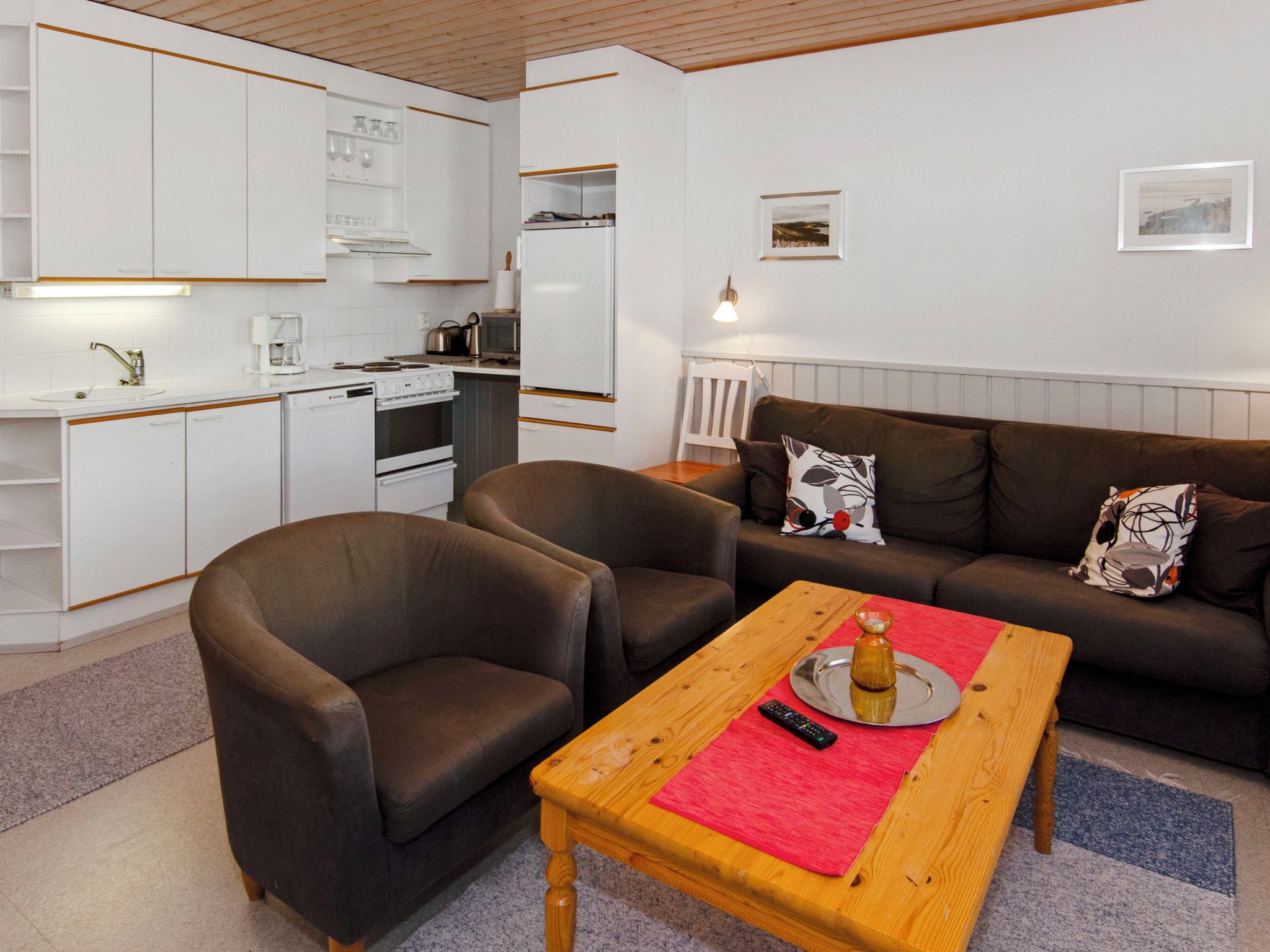 A compact living space with a kitchenette, a sofa set, and a coffee table.