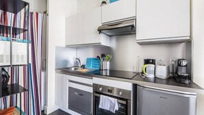 A modern kitchen with stainless steel appliances, a built-in oven, a dishwasher, and a coffee maker. - Bright and comfortable apartment - 2nd FLOOR (BORDEAUX)