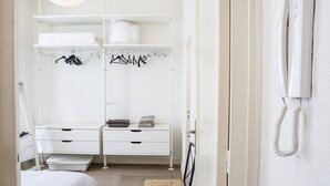 A white room with a wardrobe, a bed, and a telephone. - Martinique Street (BORDEAUX)