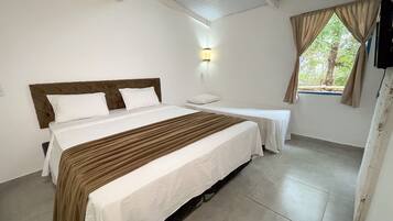 Habitación de hotel con dos camas, aire acondicionado en la pared, ventana con cortinas e iluminación en la pared.