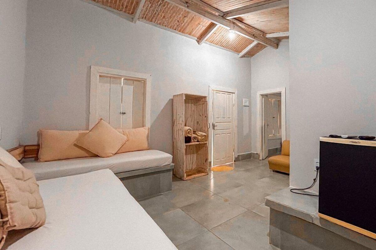 A room with a bed, a sofa, a wooden wardrobe, and a desk with a computer.