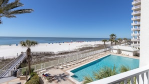 Un complexe hôtelier doté d’une piscine, d’une plage et offrant une vue sur l’océan.