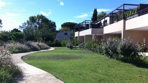 Un chemin menant à un bâtiment doté d’un toit plat et d’un balcon.