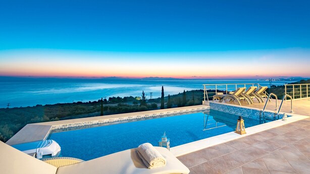 A swimming pool with a view of the sea and mountains at sunset. - Sea View Nisaki Villa with private pool! (Zakynthos)