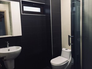 Een bad/douchecombinatie, een haardroger, handdoeken, zeep