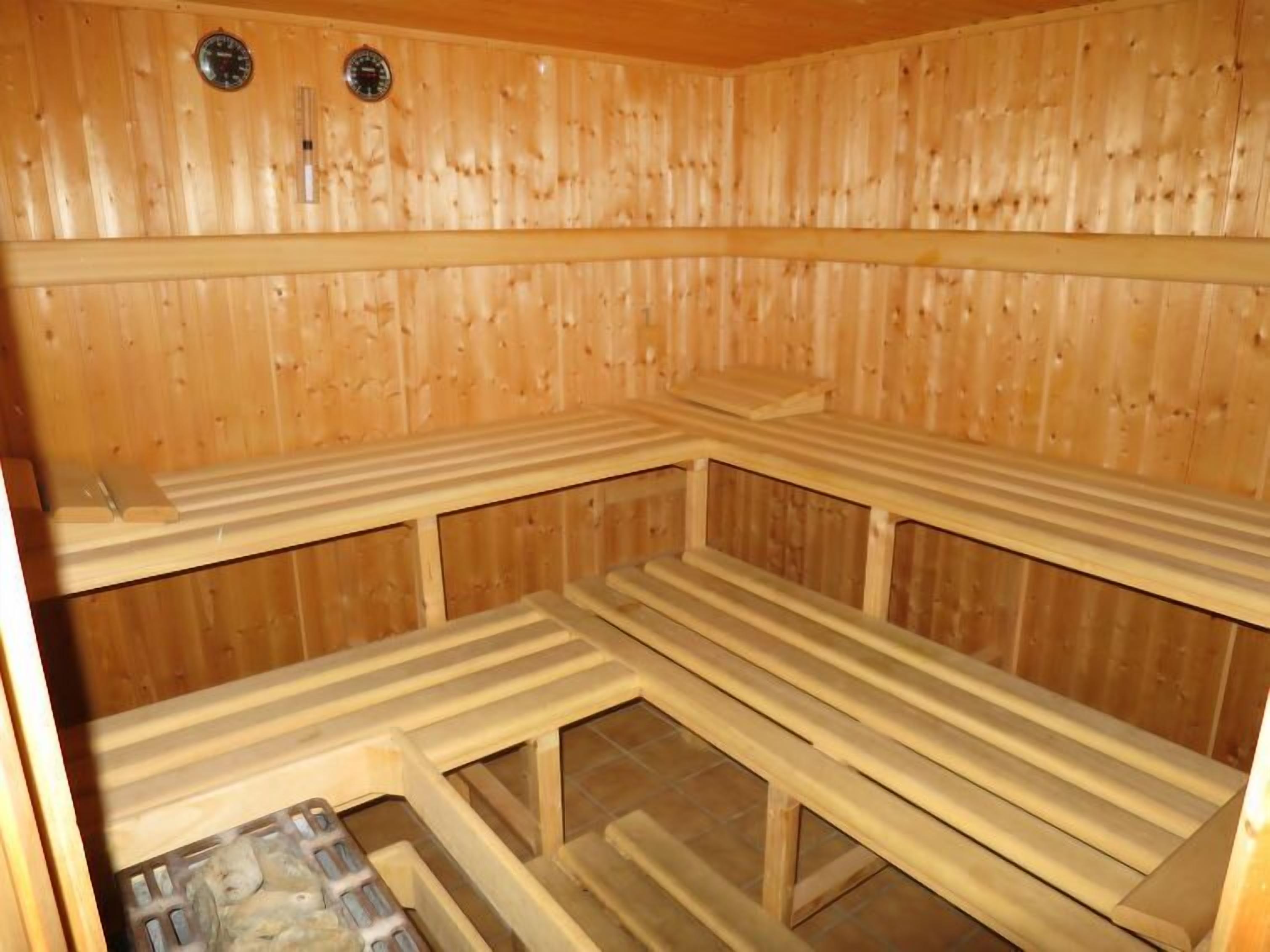 Un sauna avec des murs et des bancs en bois.