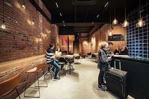 A modern interior with brick walls, hanging pendant lights, and a bar area. - Hot Jazz 11 - Habitat Apartments (Barcelona)