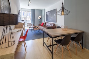 Un salon moderne avec un coin repas, comprenant un canapé, une table basse et une table à manger avec des chaises.