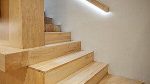Una escalera de madera con diseño moderno que conduce a un piso superior.