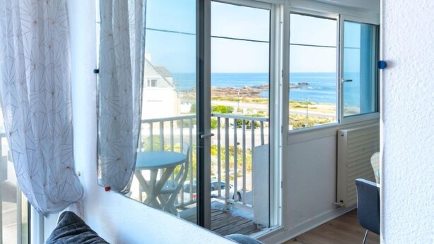 A balcony with a view of the sea, a white table, and a chair. - Les Brisants by Interhome (Quiberon)
