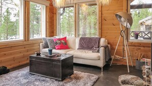 En mysig stuga med en soffa, ett soffbord och en golvlampa.