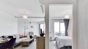 Een moderne, goed verlichte woonkamer met een bank, salontafel en een eethoek.