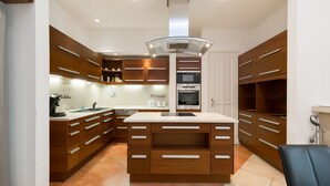 Une cuisine moderne avec des meubles en bois, un îlot central et des appareils électroménagers intégrés.