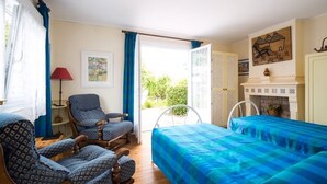 A room with a bed, two chairs, a table, a lamp, and a fireplace. - 1-ROOM APARTMENT "La Creperie" (lege cap ferret)