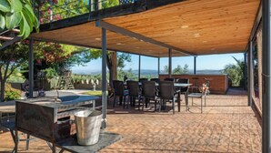 An outdoor patio with a wooden pergola, seating area, and a barbecue grill. - El Balcon by Interhome (Córdoba/Baena)