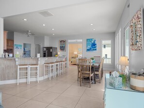 A spacious kitchen with a central island, bar stools, and a dining area with chairs. - Oceanfront,private pool,elevator,views galore!Located in Spinnakers Reach (Emerald Isle)