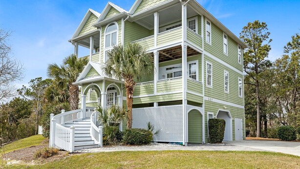 A two-story house with a porch, a staircase, and a garage. - Oceanside Interior Home,Private Pool,Golf Cart,Beach Access,in Spinnaker's Reach (Emerald Isle)