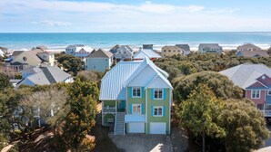 A coastal residential area with houses, a beach, and a clear sky. - Oceanview with elevator, private pool, golf cart, in Spinnakers Reach community (Emerald Isle)