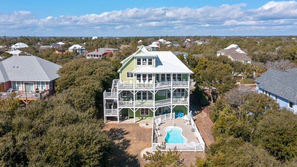 A two-story house with a large deck and a swimming pool. - Oceanview with elevator, private pool, golf cart, in Spinnakers Reach community (Emerald Isle)