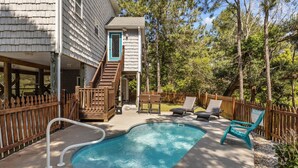 A backyard with a swimming pool, wooden deck, and a wooden fence. - Pet Friendly, Oceanside Interior Home Private Pool, Golf Cart, and Easy Access. (Emerald Isle)