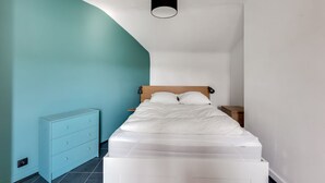 A bedroom with a bed, a nightstand, a dresser, and a curved ceiling. - The Heart of Amboise, three-room apartment, two bedrooms in the city center (Amboise)