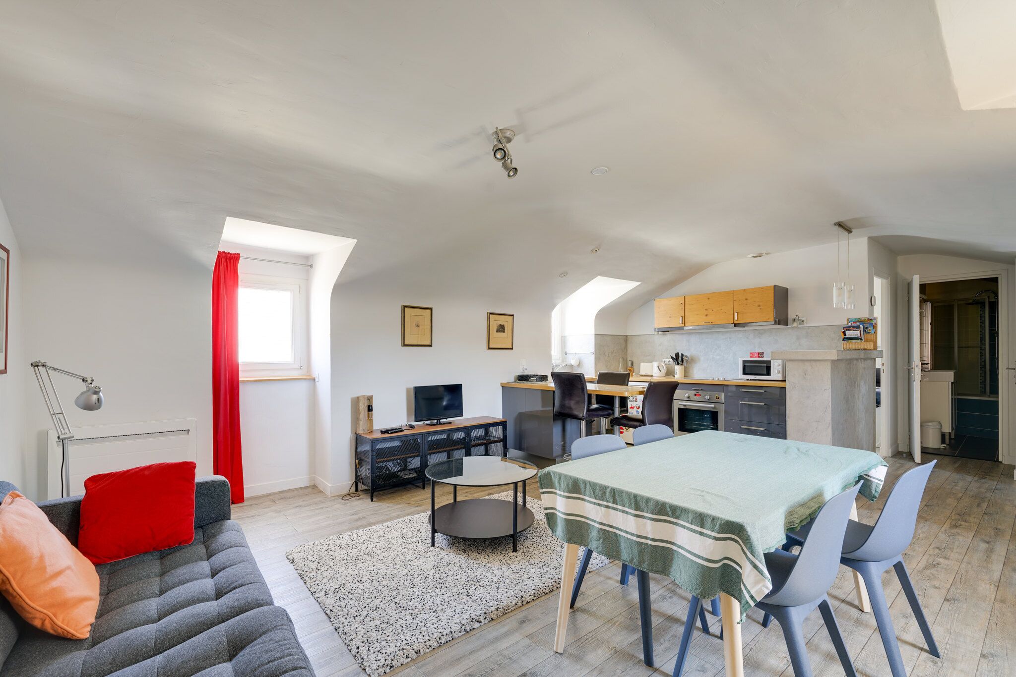 A modern apartment with a dining area, kitchen, and living space.