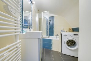 Bathtub, hair dryer, towels, shampoo