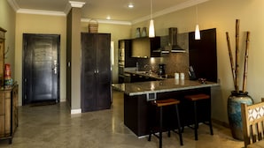 A modern kitchen with dark cabinetry, a granite island, and pendant lighting.