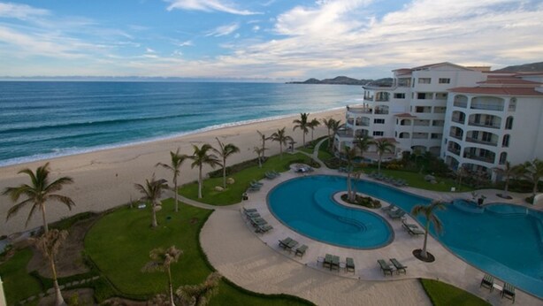 Un resort con una gran piscina, playa y vista al océano.