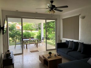 Uma sala de estar moderna com um sofá, uma mesa de centro e um espaço de jantar com mesa e cadeiras.