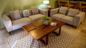 Una sala de estar con un sofá, una mesa de centro y una lámpara.