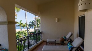 A balcony with two lounge chairs, a view of the beach, and a tiled floor. - Las Mananitas C308 3 BR by Casago (San José del Cabo)