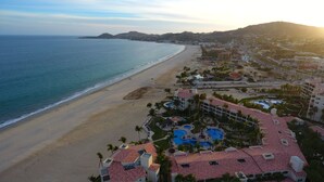 A coastal resort with a beachfront, a swimming pool complex, and a hilly backdrop. - Las Mananitas C308 3 BR by Casago (San José del Cabo)