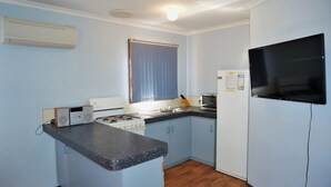 A compact kitchen with a gas stove, microwave, and a refrigerator. - 10 Tautog Street - Great Family space in central location (EXMOUTH)