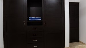 Un armario de madera oscura con varios cajones y un estante.