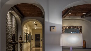 Ein Flur mit Holzboden, einem Wandthermostat und einer dekorativen Lampe.