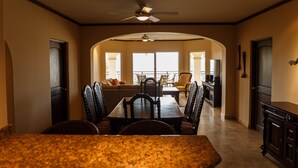 A dining area with a granite countertop, dark wooden chairs, and a ceiling fan. - Las Mananitas E3301 2 BR by Casago (San José del Cabo)
