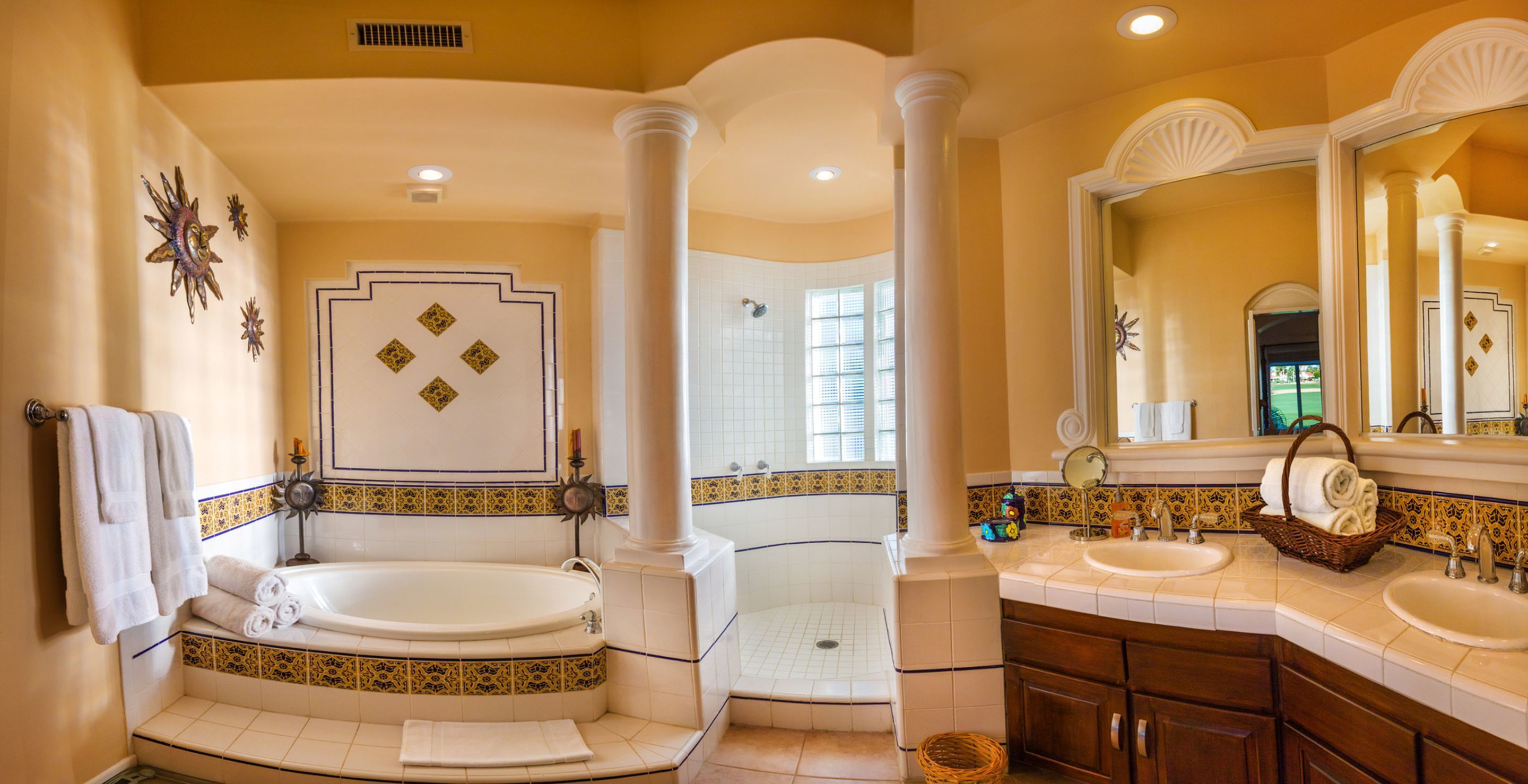 Une salle de bain luxueuse dotée d’une grande baignoire, d’une douche séparée et d’un meuble-lavabo avec un miroir.