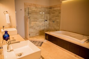 A modern bathroom with a glass-enclosed shower, a large bathtub, and a white sink. - Cascadas de Pedregal 711 3 BR by Casago (Cabo San Lucas)