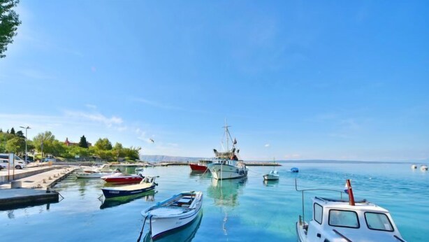 A marina with several boats docked, a pier with a few vehicles, and a clear blue sky. - Apartment Josipa by Interhome (Novi Vinodolski/Klenovica)