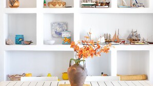 Een eettafel met een bloevas, omringd door witte stoelen.