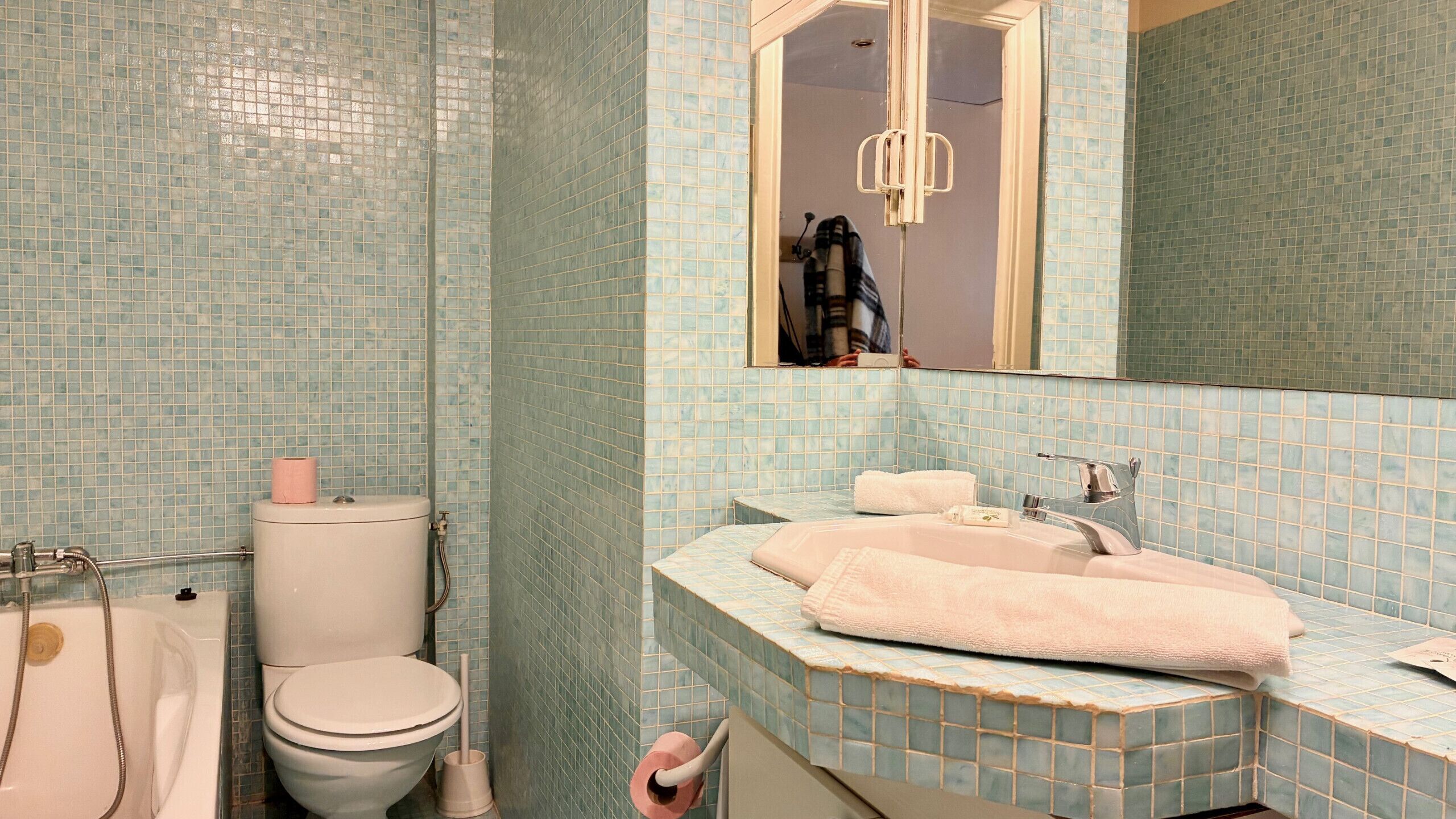 Un bagno con il water, un lavandino e uno specchio.