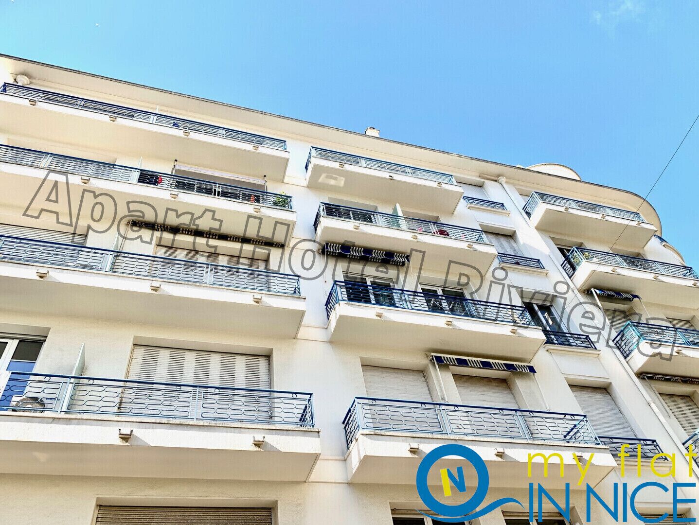 Un immeuble à plusieurs étages, doté de balcons et d’une enseigne indiquant « Appartements ».