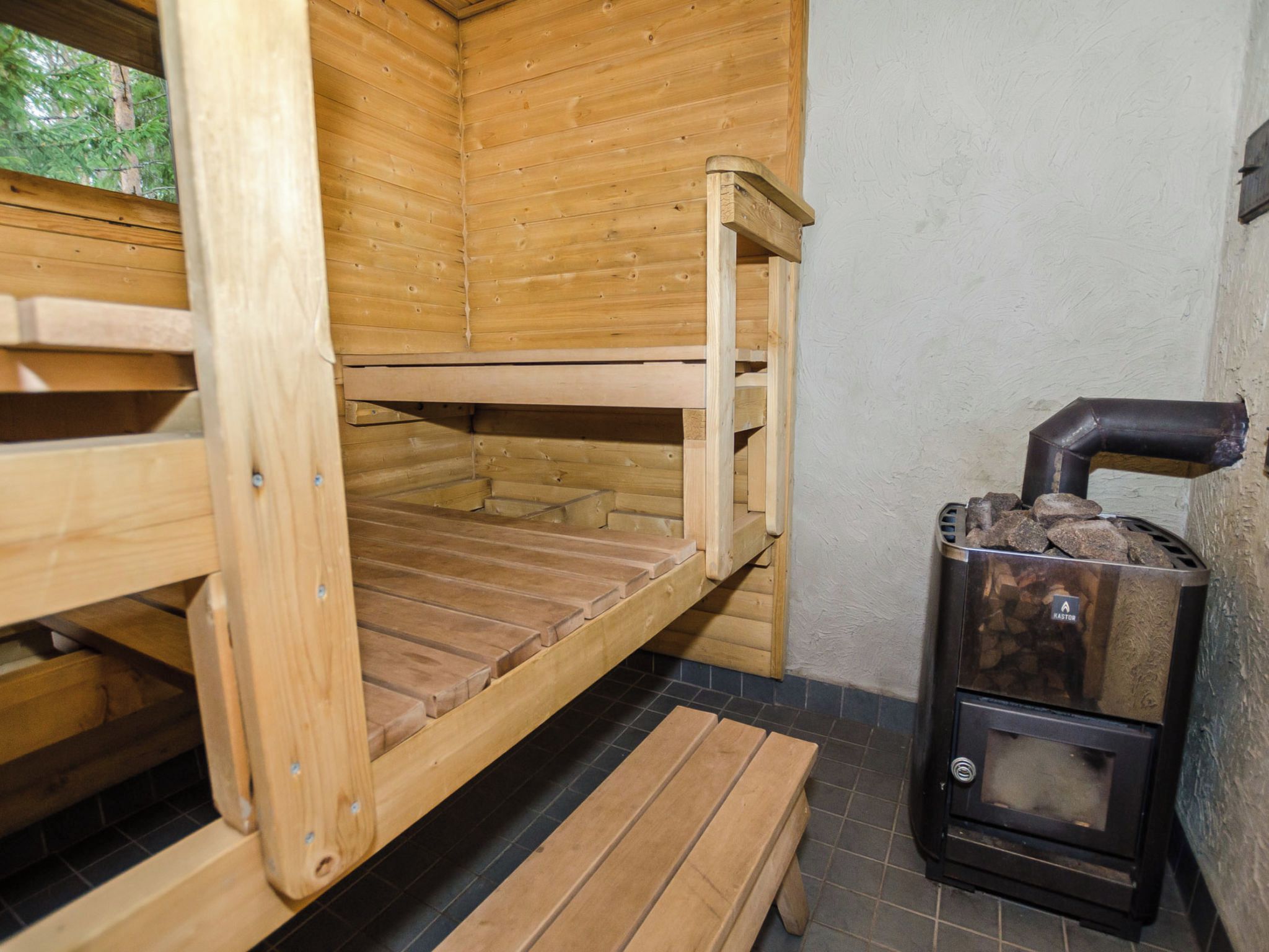 A sauna room with wooden benches and a stone fireplace.