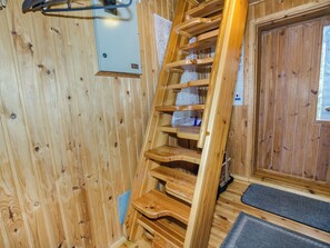 A wooden interior with a wooden staircase, a door, and a small window. - Kanerva by Interhome (Juuka)