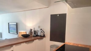 A modern kitchen with a wooden countertop, a black induction cooktop, a kettle, and a coffee maker. - Beautiful comfortable apartment at the foot of the slopes with internet (Isola 2000)