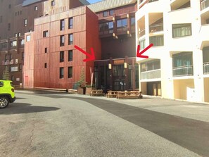 Un hôtel au design moderne, caractérisé par une grande façade en bois et un bâtiment blanc doté de balcons.