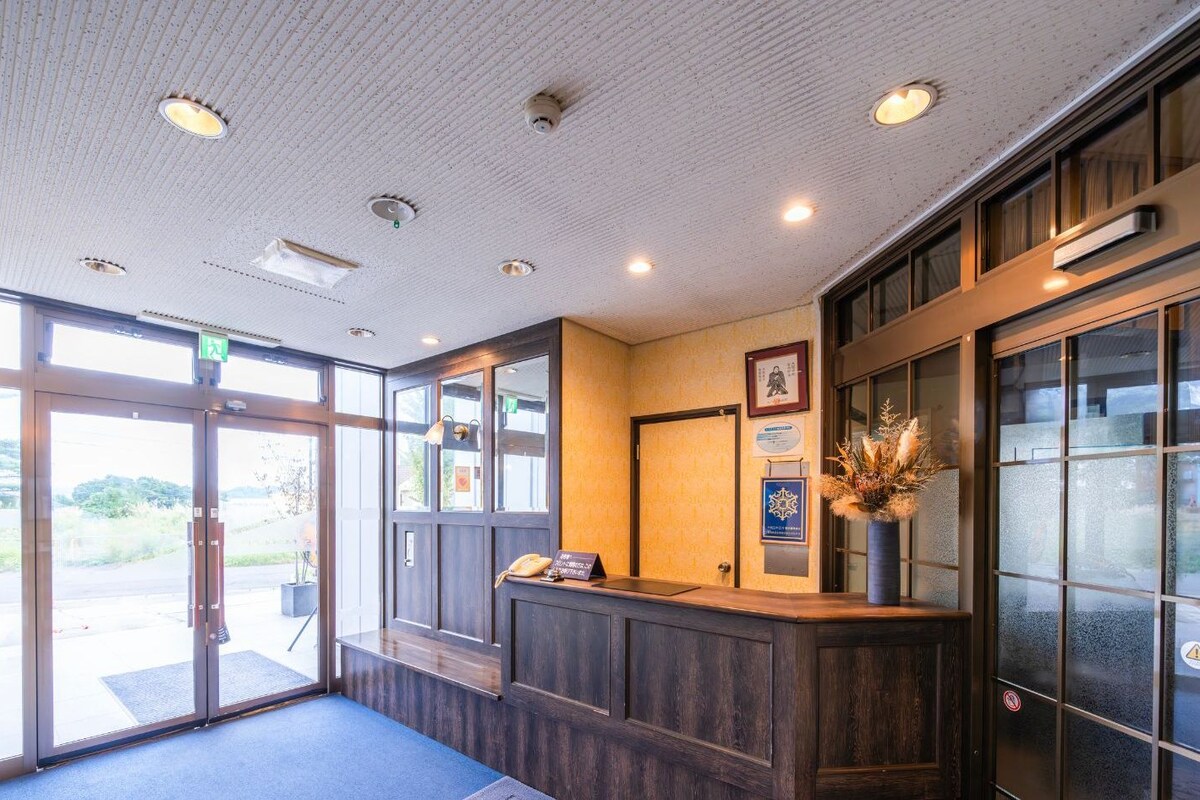 A reception area with a wooden counter, glass doors, and a blue carpet.