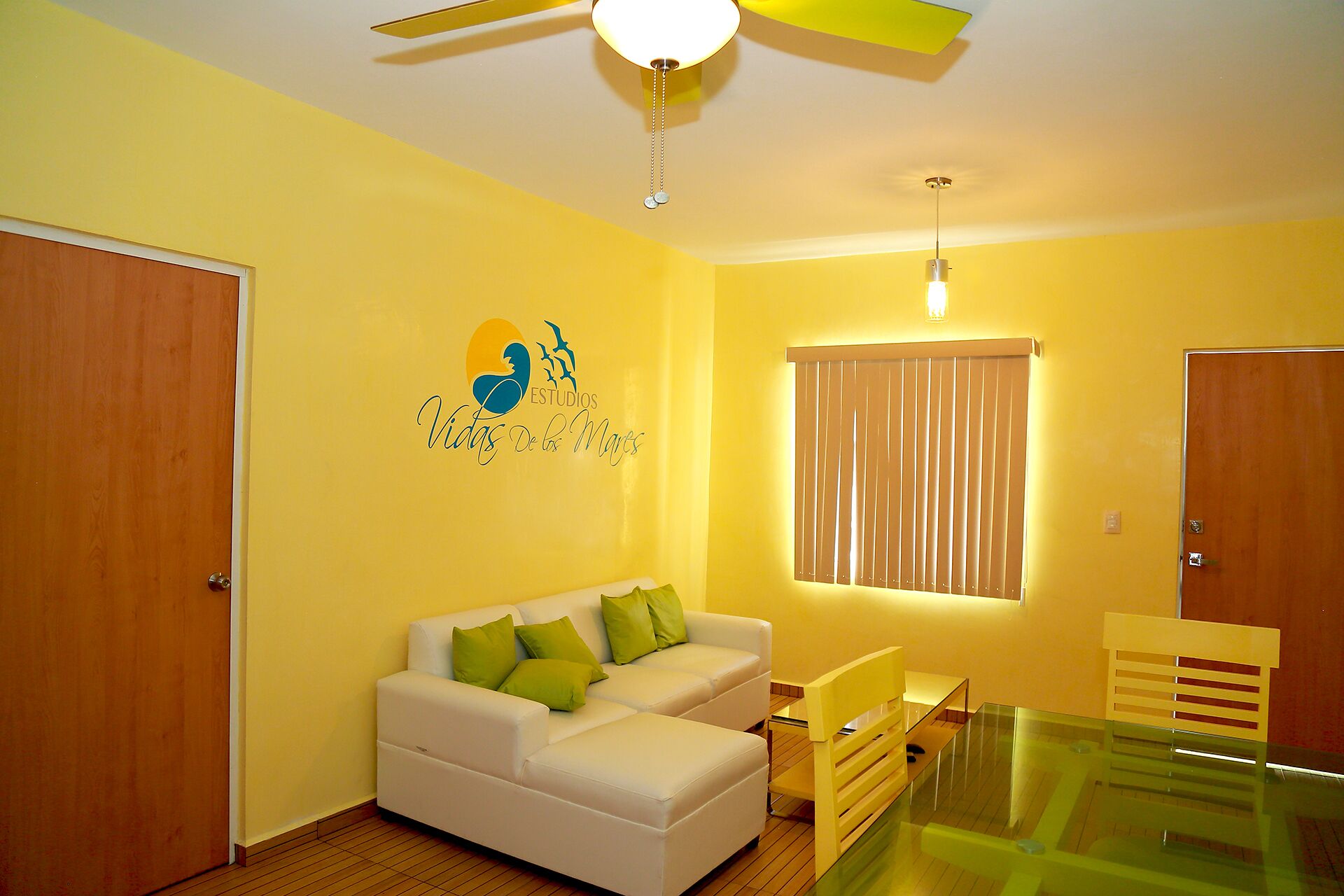 A room with a white sofa, green cushions, a glass table, and a ceiling fan. - In Playa del Carmen, Mexico (Playa del Carmen)